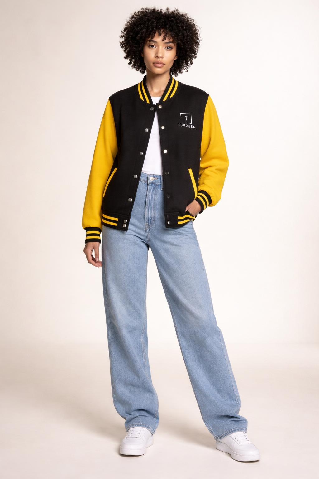 Full body view of the model wearing Tovolea Ladies Classic Yellow & Black Letterman Jacket