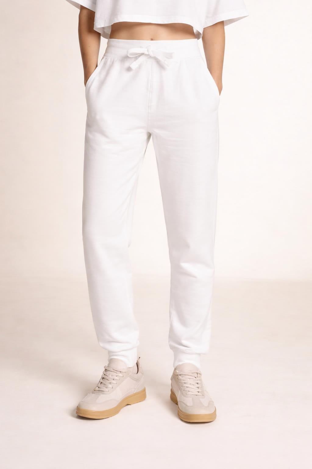 Close-up of the model's lower body wearing Tovolea Embroidered White Fleece Sweatpants