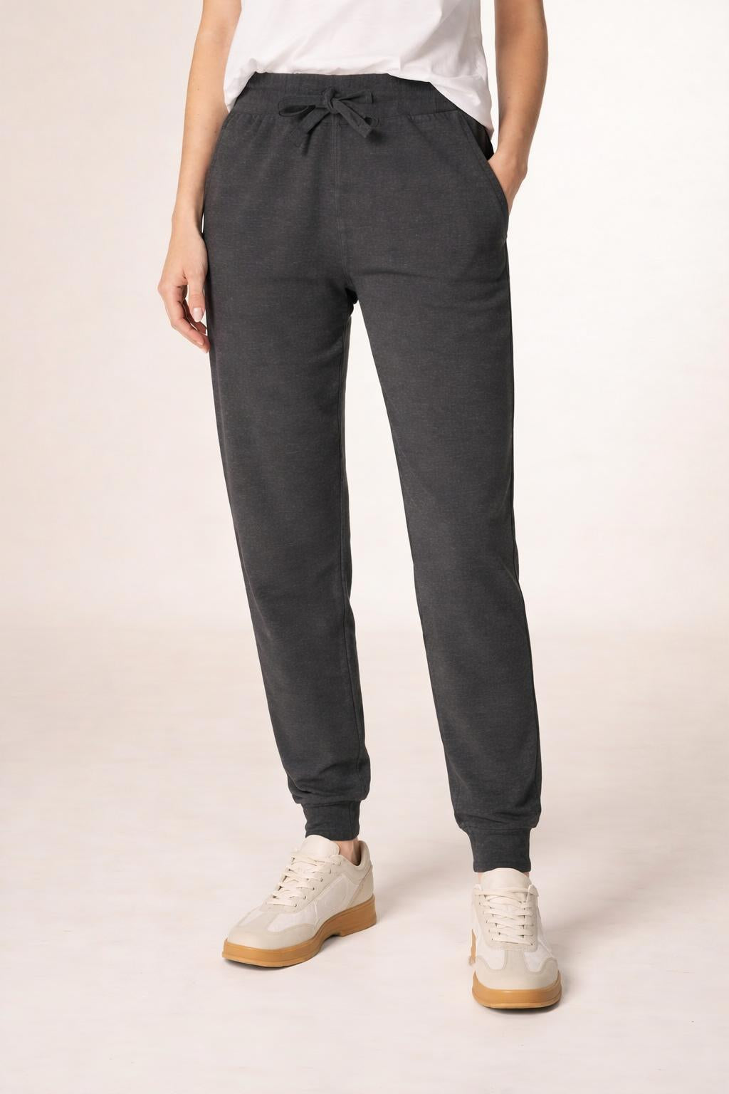 Close-up of the model's lower body wearing Tovolea Embroidered Black Fleece Sweatpants