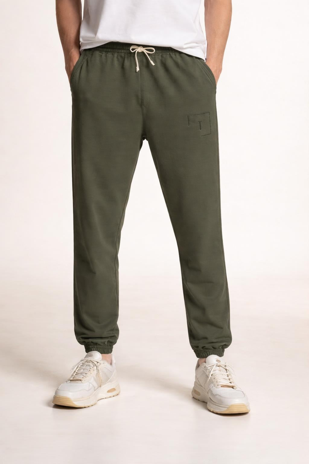 Close-up of the model's lower body wearing Tovolea Gents Grey Embroidered Fleece Sweatpants