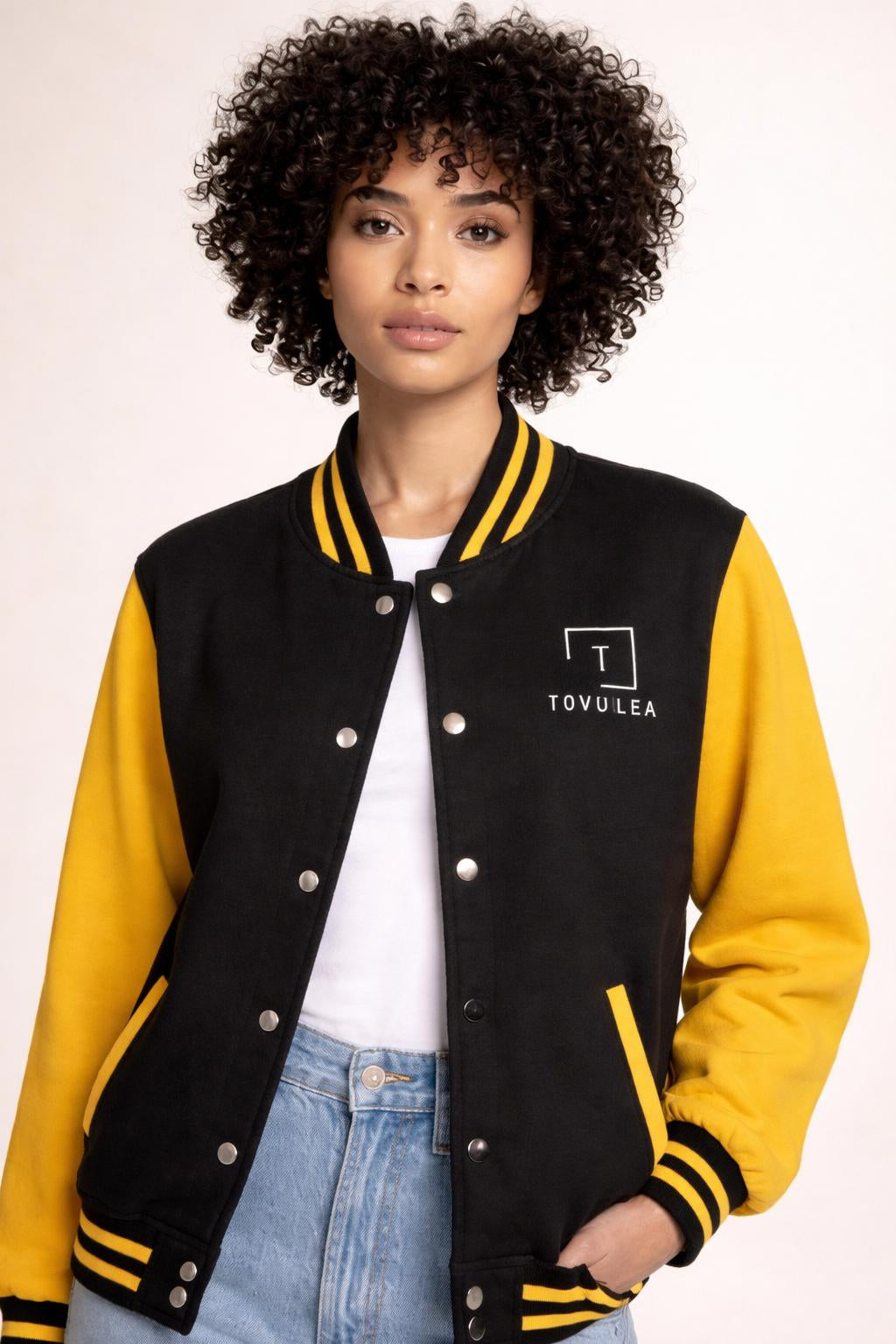 Close-up of the model wearing Tovolea Ladies Classic Yellow & Black Letterman Jacket