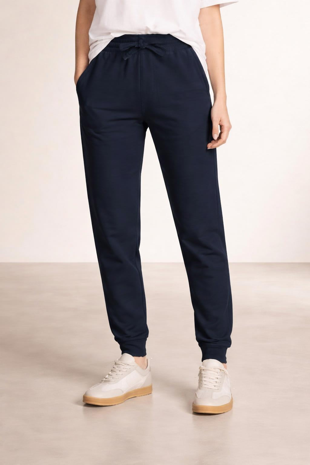Close-up of the model's lower body wearing Tovolea Embroidered Navy Blue Fleece Sweatpants